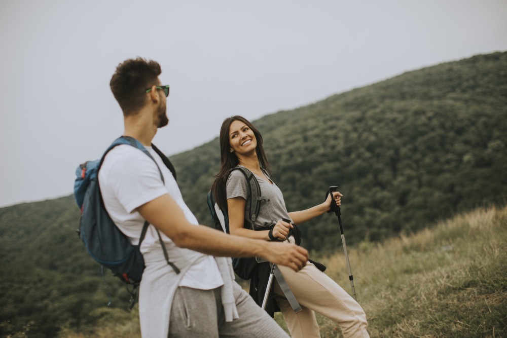 smiling-young-couple-walking-with-backpacks-on-the-2023-11-27-05-03-33-utc.jpg